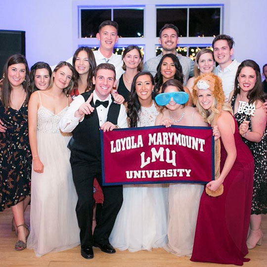 Group photo at a wedding with LMU flag